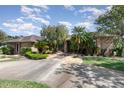 Inviting single-story brick home with a well-manicured lawn, a variety of trees, and a concrete driveway leading to the entrance at 3 Whipper In Cir, Ormond Beach, FL 32174