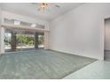 Spacious living room with plush carpeting, high ceilings, and a large sliding glass door leading to the outdoor patio at 3 Whipper In Cir, Ormond Beach, FL 32174