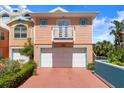 Charming beach house with white garage doors and a quaint balcony at 3000 Ocean Shore Blvd # 6, Ormond Beach, FL 32176