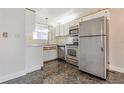 Compact kitchen with stainless steel appliances, bright cabinets, and window for natural light at 313 Dirksen Dr # G4, Debary, FL 32713