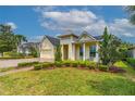 Inviting yellow home boasting manicured landscaping, a brick driveway, and a charming front porch at 341 Chelsea Place Ave, Ormond Beach, FL 32174