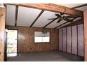 Spacious living room with wood paneling, ceiling fan, and natural light, creating a cozy atmosphere at 34416 Oak Ave, Leesburg, FL 34788