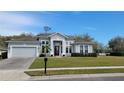 Charming one story home with lush landscaping, a well-manicured lawn, and attached garage at 421 Holly Fern Trl, Deland, FL 32720