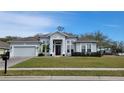 Charming one story home with lush landscaping, a well-manicured lawn, and attached garage at 421 Holly Fern Trl, Deland, FL 32720