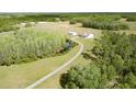 Expansive aerial view of the property highlighting its long driveway, separate shed, pond, and natural surroundings at 4503 Colony Rd, New Smyrna Beach, FL 32168