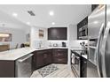 Well-appointed kitchen boasts dark wood cabinetry, stainless steel appliances, and marble countertops at 5207 S Atlantic Ave # 723, New Smyrna Beach, FL 32169