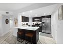 Modern kitchen featuring dark cabinets, stainless appliances, marble counters, and a cozy breakfast bar at 5207 S Atlantic Ave # 723, New Smyrna Beach, FL 32169