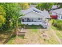 Aerial view of a home with a quaint front porch and lush greenery surrounding the property at 5261 3Rd St, Orlando, FL 32810