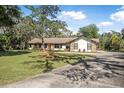 Charming single-story home featuring stone accents and a well-manicured lawn under a bright blue sky at 6247 Palomino Cir, Port Orange, FL 32127