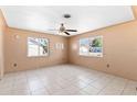 Bright living room featuring tile flooring, a ceiling fan, and many windows at 630 Florida Ave, Daytona Beach, FL 32117