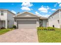 Charming home boasts a well-manicured lawn, brick paver driveway and two-car garage at 7068 Lanier Falls Rd, Deland, FL 32724