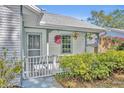 Close-up of front porch area with a white fence, hanging plants, and decorative trim at 717 S Ridgewood Ave, Ormond Beach, FL 32174
