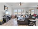 Bright living room area featuring a large, comfortable sofa with an entertainment area and natural light at 9392 Revere Ave, Leesburg, FL 34788