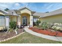 Inviting home entrance featuring a covered porch, neat landscaping, and walkway at 1033 Pearl Tree Rd, Deltona, FL 32725