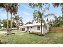 Beautiful white home with carport, metal roof, well-manicured lawn, and mature palm trees at 104 Hester Ave, New Smyrna Beach, FL 32168