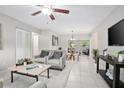 Bright living room featuring modern furniture, tile flooring, and a ceiling fan at 1044 Deltona Blvd, Deltona, FL 32725