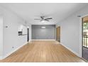 Open-concept living space with wood floors, modern ceiling fan, and sliding door access to balcony at 110 Cypress Woods Ct # 2B, Deltona, FL 32725