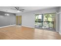 Bright living room features wood flooring, a ceiling fan, and sliding doors to the balcony at 110 Cypress Woods Ct # 2B, Deltona, FL 32725