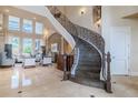Grand foyer features a sweeping staircase with wrought iron detailing, high ceilings, and tile flooring at 1117 Oxbridge Ln, Ormond Beach, FL 32174