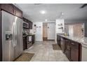 Bright, open kitchen with stainless steel appliances, dark wood cabinets, granite countertops and tiled floors at 1369 Saxon Blvd, Deltona, FL 32725