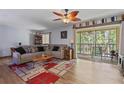 Comfortable living room featuring modern wood flooring, and a sliding glass door leading to a screened in balcony at 140 Orchid Woods Ct # 14B, Deltona, FL 32725