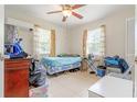 Cozy bedroom featuring a comfortable bed, natural light, and a ceiling fan at 1479 Renton St, Deltona, FL 32725