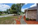 Landscaped walkway leading to the home with fresh mulch and green plants at 1491 E Palomar Dr, Deltona, FL 32738