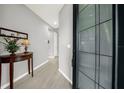Inviting entryway with gray walls, light wood-look tile flooring, and a modern, glass-paneled front door at 173 Old Moss Cir, Deland, FL 32724