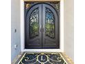Elegant arched, wrought iron double doors with glass inserts and custom monogrammed welcome mat at 1855 Cattle Creek Ln, Port Orange, FL 32128