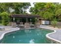 Beautiful backyard pool with a pergola, outdoor shower, stone accents and brick pavers at 1899 W Beresford Ave, Deland, FL 32720