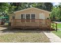 Inviting single-story home with a large wooden porch and well-maintained lawn at 211 S Delaware Ave, Deland, FL 32720