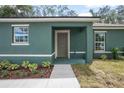 Inviting home entrance showing a walkway to a covered front door framed by white-trimmed windows at 2145 8Th Ave, Deland, FL 32724