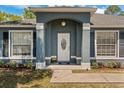 Inviting front entrance with decorative columns, arched entryway, and lush landscaping at 2150 Deck Ct, Deltona, FL 32738