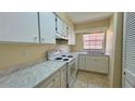 Bright kitchen with white cabinets, marble countertops, and a window overlooking the neighborhood at 2200 S Palmetto Ave # B060, Daytona Beach, FL 32119