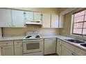 Well-lit kitchen featuring white appliances, marble countertops, and ample cabinet space at 2200 S Palmetto Ave # B060, Daytona Beach, FL 32119