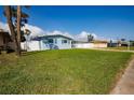 Single-story home featuring a well-maintained lawn, beautiful blue exterior, and white fence at 2573 W Coral Way, Daytona Beach, FL 32118