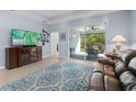 Spacious living room with tile flooring, entertainment center, and sliding glass doors to the screened lanai at 262 Coral Reef Way, Daytona Beach, FL 32124