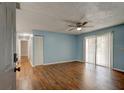 Inviting living room with wood floors, a ceiling fan, and sliding glass doors at 2706 Oak Trail Run # 6, Port Orange, FL 32127