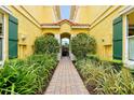 Inviting walkway through lush landscaping to building entrance with beautiful archway and red tile roof at 2982 S Atlantic Ave, New Smyrna Beach, FL 32169