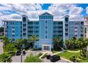 Stunning exterior of a condo building with breezy balconies, palm trees and neatly manicured landscaping at 3 Riverwalk Dr # 404, New Smyrna Beach, FL 32169