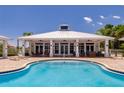 Community swimming pool featuring poolside seating, a covered pavilion, and lush landscaping at 3 Riverwalk Dr # 404, New Smyrna Beach, FL 32169