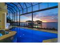 Screened in pool featuring views of the inter coastal waterway at sunset at 3310 John Anderson Dr, Ormond Beach, FL 32176