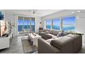 Inviting living room with a gray sectional sofa, modern coffee table, and expansive ocean views from large windows at 3425 S Atlantic Ave # 1206, Daytona Beach Shores, FL 32118