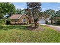 Beautiful brick home with an attached garage, neat landscaping, and a well-maintained lawn at 405 Secluded Oaks Trl, Deland, FL 32724