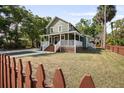 Charming two-story home featuring a covered front porch and a well-manicured lawn, creating a welcoming curb appeal at 415 W Church St, Deland, FL 32720