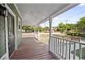 Spacious front porch with wood flooring offers a relaxing outdoor space with views of the neighborhood at 415 W Church St, Deland, FL 32720