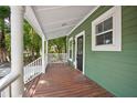 Inviting front porch features wood flooring, white railings, and a cozy seating area for relaxation at 415 W Church St, Deland, FL 32720