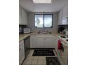 Cozy kitchen featuring white cabinets, stainless steel appliances, and a garden view window at 4401 Sea Mist Dr # 201, New Smyrna Beach, FL 32169