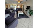 Open-concept living room boasts tile floors, ceiling fan, and comfortable seating area at 4401 Sea Mist Dr # 201, New Smyrna Beach, FL 32169