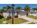 Attractive house boasts arched windows, lush greenery, a well-kept lawn, and an attached two-car garage at 4534 Bond Ln, Oviedo, FL 32765